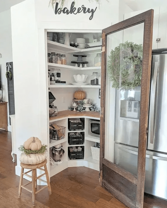 a cool and cozy little pantry with built-in shelves and cubbies, appliances, cookware and some decor