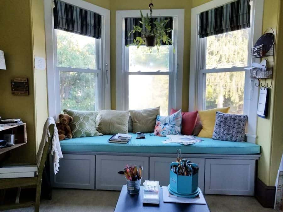 Bay window seat, blue cushion, living room, hanging potted plant 