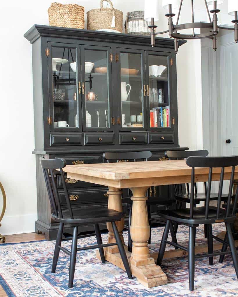 Transitional dining room with black cabinet and wooden table 