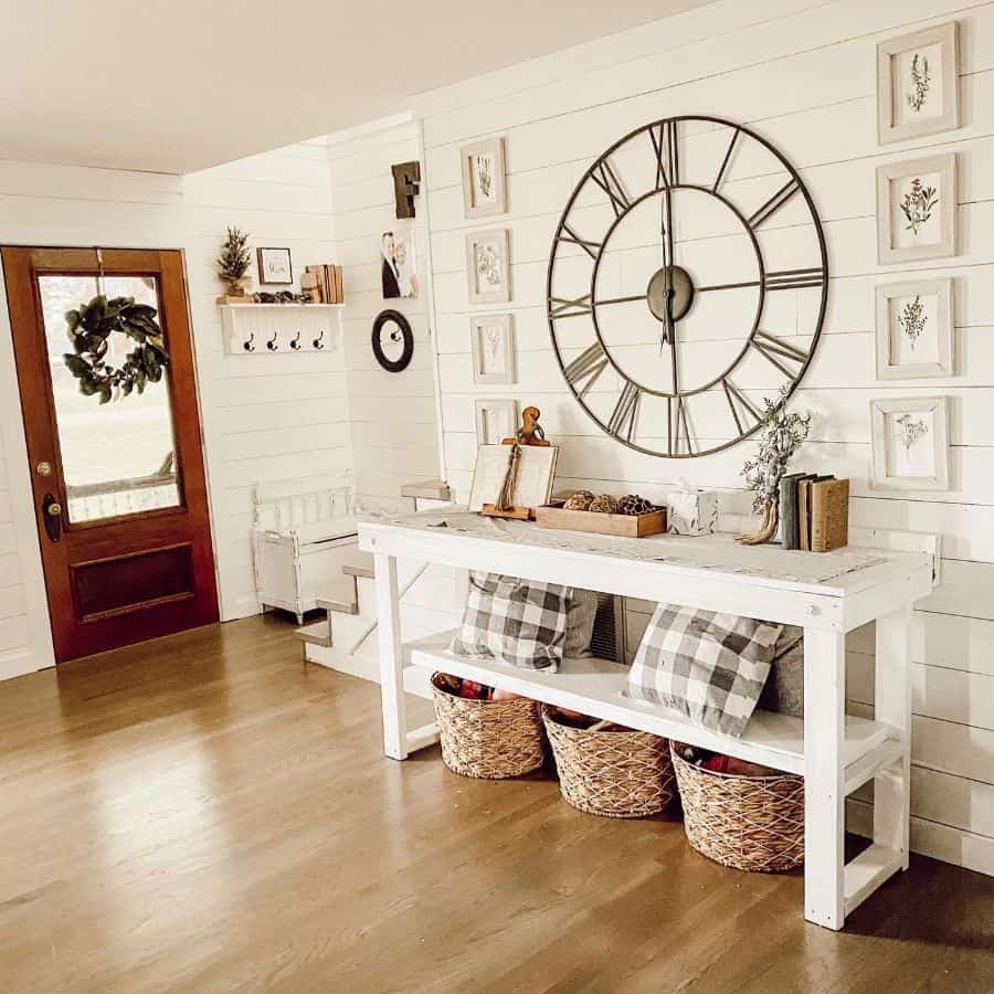 Modern farmhouse entrance with large rustic wall clock and white table 