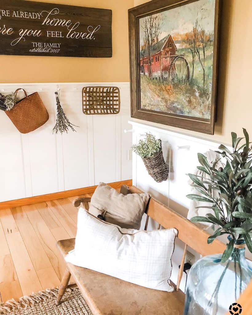 Farmhouse living room with vintage wall painting and bench 