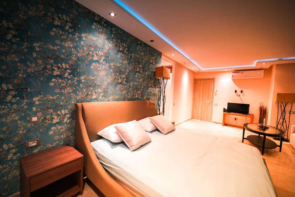 Floral wallpaper, bedroom, orange bed, LED ceiling lighting 