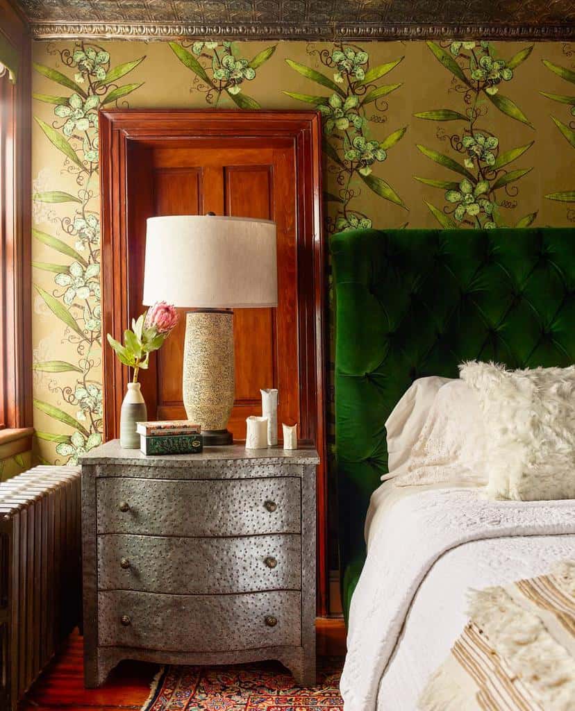 Nature inspired bedroom wallpaper, green velvet headboard, brown door