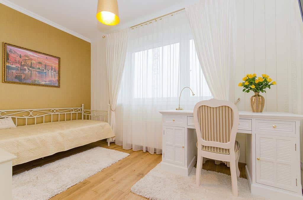 Textured mustard wall, white carpet, white desk, white curtains 