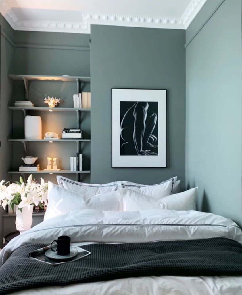 Small bedroom with green wall and recessed shelves 