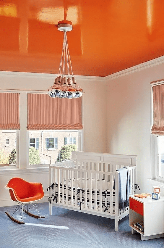 a bright orange blanket, matching chair and drawer to create an eye-catching and inviting children's room