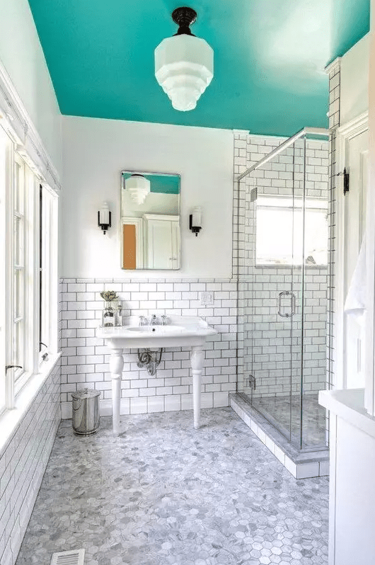 a neutral bathroom jazzed up with a bold aqua ceiling that adds color and doesn't make the room boring