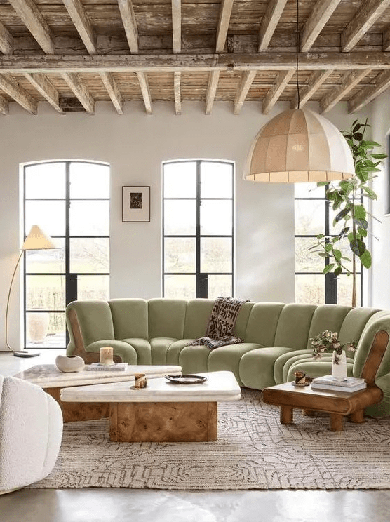 an elegant living room with tall windows, a light green cotton sofa, two coffee tables and a few chairs
