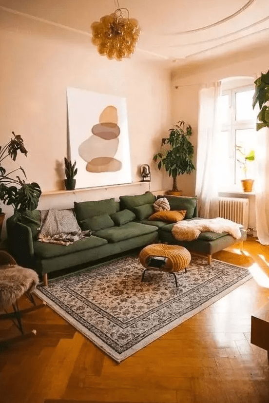 a muted and warm-colored living room with tan walls and ceiling, a green seating area, a woven stool, a printed rug and potted plants