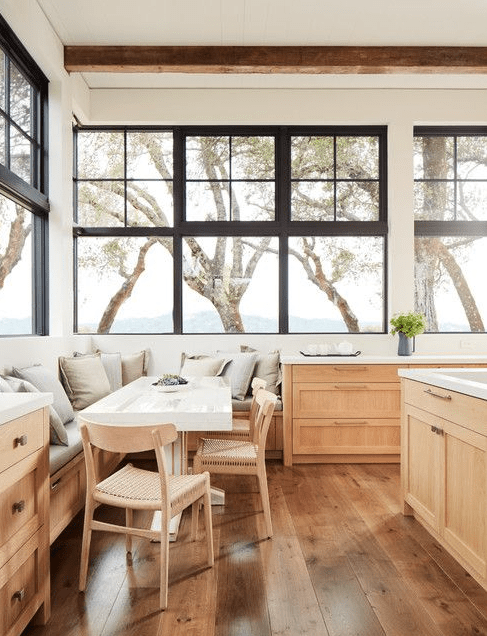 An airy kitchen with great views, stained base cabinets and a cozy dining area are fantastic