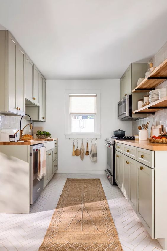 a gray farmhouse kitchen with white herringbone flooring, butcher block countertops and open shelving, and a jute rug