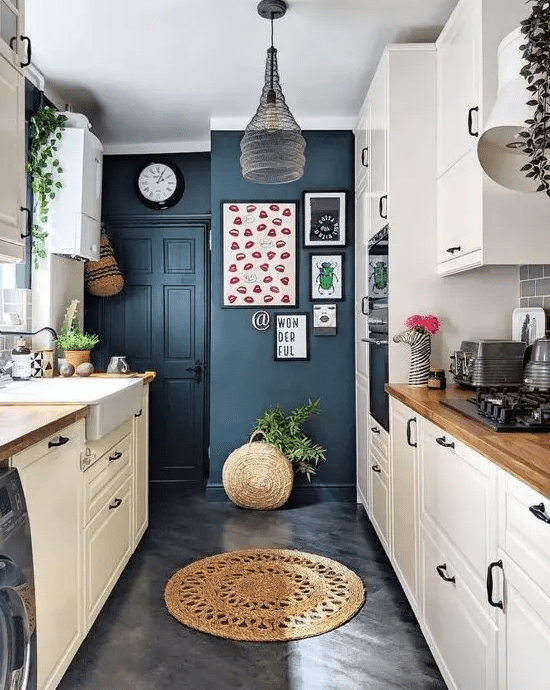 a neutral kitchen with navy blue walls, a pendant lamp, potted plants, wooden countertops and a bright gallery wall