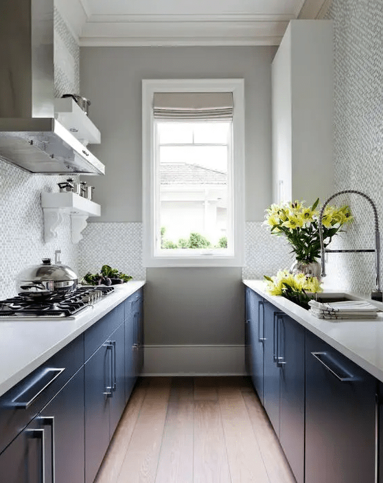 A stylish kitchen with navy blue cabinets, white stone countertops, and a neutral tile backsplash is a cool idea if you don't have much space
