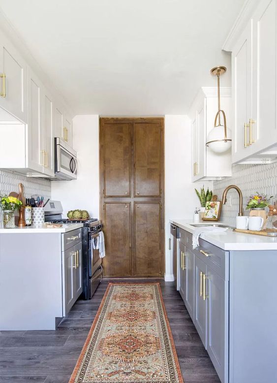 A modern farmhouse kitchen in blue with white countertops and gold accents and lights for a chic look