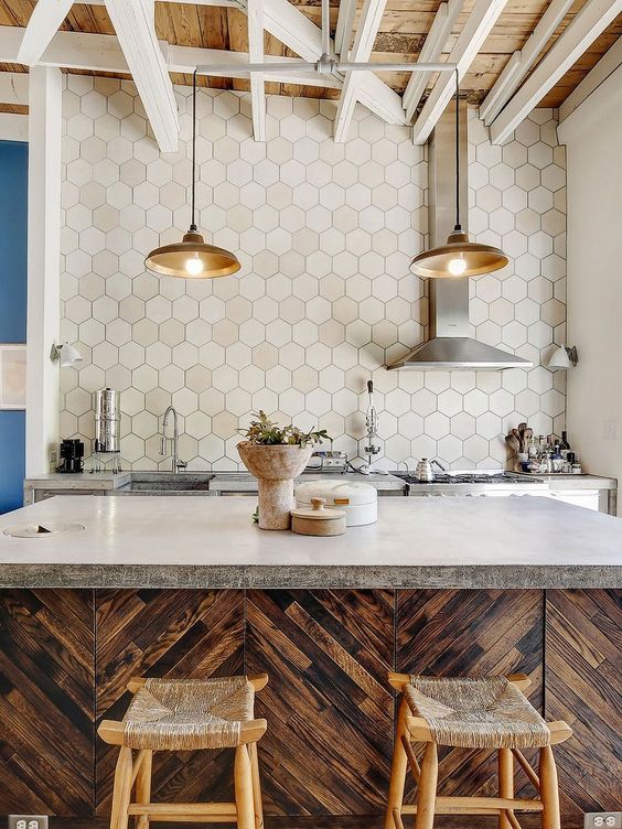 a whimsical kitchen with richly stained cabinets, concrete countertops and an extended hexagonal tile backsplash, plus pendant lamps