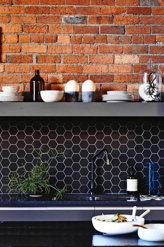Black hexagonal tile backsplash with white grout and exposed red brick to highlight your kitchen