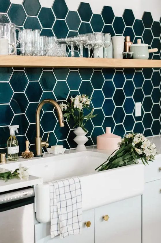 Shiny emerald green hexagon tiles, brass accents and wood make the kitchen super chic