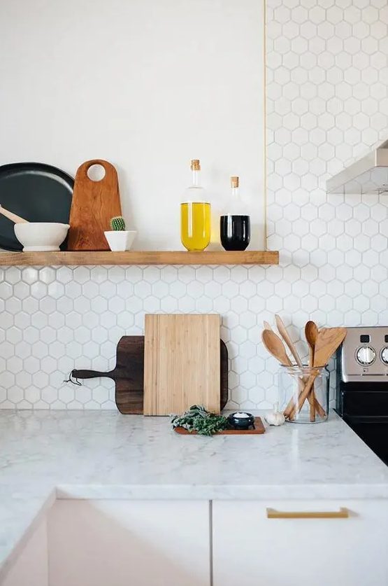 Small hexagonal marble tiles and a marble countertop work harmoniously together to create a seamless surface