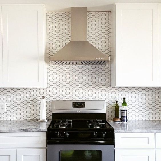 Small white hexagon tiles with black grout stand out and make the backsplash an eye-catcher
