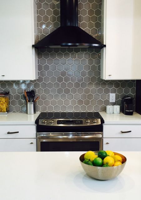 A kitchen splashback made of gray hexagonal tiles with white grout adds color to the room and makes it more memorable