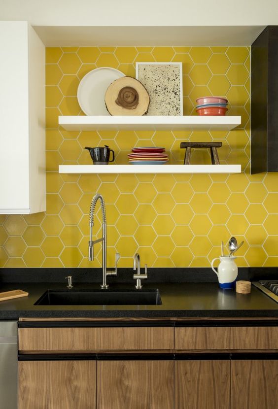 Bold yellow hex tiles with white grout accent the black cabinets and add color to the room