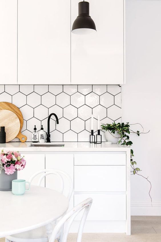 Large format white hexagon tiles with black grout fit perfectly into a minimalist or Scandinavian kitchen