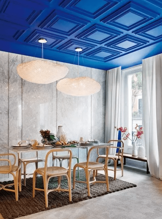 An electric blue paneled ceiling is a key color and design feature of the dining room