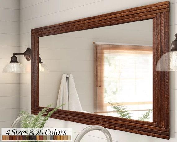 Hang a large mirror with a wooden frame to contrast against your wooden bathroom