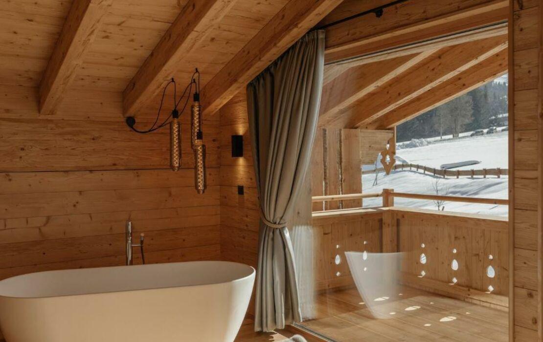 A wooden bath caddy for soaking with a book in the Chalet Bathroom